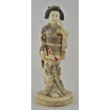 An early 20th Japanese carved ivory figure of a lady wearing a kimono holding a flowering branch,