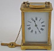 A brass cased carriage clock with a white enamel dial and black Roman numerals,
