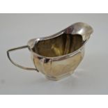A silver cream jug, Birmingham 1910, of rounded rectangular outline, 112 g (3.