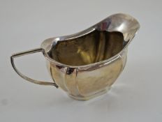 A silver cream jug, Birmingham 1910, of rounded rectangular outline, 112 g (3.