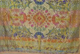 A large Indian silk throw, machine woven with figures in a garden within decorative borders,