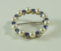 A cultured pearl and sapphire circlet brooch, stamped '750', 3.