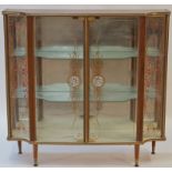 A 1960s display cabinet with walnut effect carcass and painted glazed doors, 101cm high, 106cm wide,