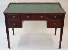An Edwardian mahogany desk with pierced gallery back,