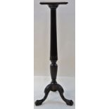 A mahogany torchere with carved and reeded column support on three shaped legs and carved paw feet,