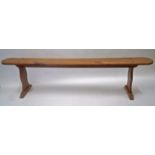 A French fruitwood bench, the shaped legs with flared plinth base, 48cm high, 198cm long, 21.