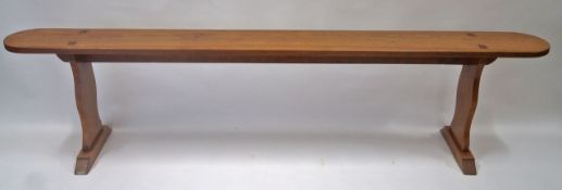 A French fruitwood bench, the shaped legs with flared plinth base, 48cm high, 199cm long, 21.