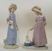 A Lladro figure of a young girl pulling her doll in a small cart, printed factory marks in blue, 26.