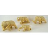 Four late 19th century carved ivory figures of elephants, one standing on a rectangular plinth,