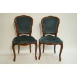 A pair of French walnut side chairs in Louis XVI style, each with padded back and seat,