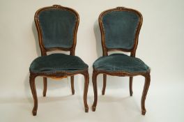 A pair of French walnut side chairs in Louis XVI style, each with padded back and seat,