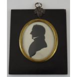A 19th century silhouette of a young man facing left in rectangular black lacquered frame,