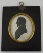 A 19th century silhouette of a young man facing left in rectangular black lacquered frame,