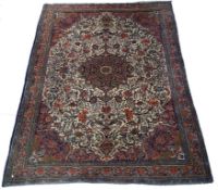 A large Iranian Bijar rug with central medallion and spandrels on a repeating scrolling flower and