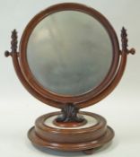 A Victorian mahogany swing mirror on unusual marble and mahogany round base on bun feet,