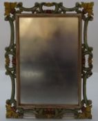 A wall mirror with decorative carved wood and painted frame,