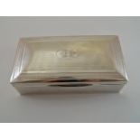 A silver cigarette box, marks worn, with engine turned decoration and monogrammed cartouche,