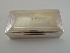 A silver cigarette box, marks worn, with engine turned decoration and monogrammed cartouche,