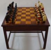 A 20th century chess table with a frieze drawer together with painted plaster Alice in Wonderland