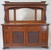 An early 20th century oak Art Nouveau style sideboard with triple mirrored back above two drawers,