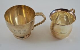 A silver mug, by Walker & Hall, Sheffield 1930, inscribed, 7 cm high; with a smaller silver mug,