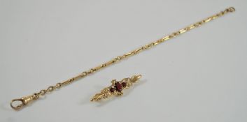 A 9 carat gold bracelet, of fetter and three links, 20 cm long; with a garnet set brooch,