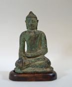 A bronze figure of a Buddha seated with crossed legs, on fitted wooden stand,