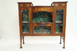 An Edwardian mahogany display cabinet with Art Nouveau style marquetry and stained glass panels,