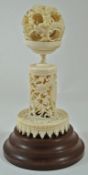 A late 19th century Chinese carved ivory concentric ball and stand, pierced and carved with dragons,