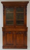 A Victorian walnut bookcase with two glazed doors above a cushion moulded drawer and two panelled