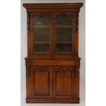 A Victorian walnut bookcase with two glazed doors above a cushion moulded drawer and two panelled