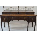 A Regency mahogany sideboard with raised brass back above carved blind fret work sliding doors,