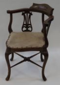 An Edwardian mahogany inlaid corner chair with pierced splats and cabriole legs linked by turned