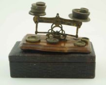 A set of postal scales on walnut base, 17cm wide with associated weights,