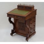 A late Victorian mahogany Davenport with leather inset top and carved panels,