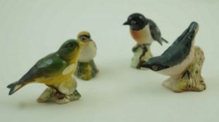 A collection of four Beswick figures of birds, comprising of a Stonechat, a Greenfinch,