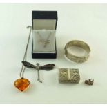 A silver hinged bangle; a dragonfly brooch; an amber pendant on a chain;
