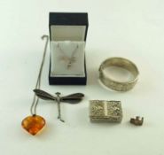 A silver hinged bangle; a dragonfly brooch; an amber pendant on a chain;