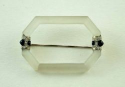 A frosted rock crystal frame brooch, set with diamonds and black enamel motifs impaling either end,