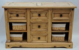 A stripped softwood sideboard with three drawers above  two shelves flanking two drawers on plinth