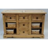 A stripped softwood sideboard with three drawers above  two shelves flanking two drawers on plinth