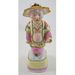 A German porcelain figure of a Chinaman, his leaf shaped hat picked out in gilt,