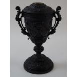 An Edwardian cast spelter oil lamp with bacchanalian figures, two pierced handles and flared base,