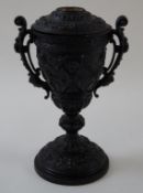 An Edwardian cast spelter oil lamp with bacchanalian figures, two pierced handles and flared base,