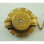 A Victorian gold brooch, of circular outline and set with a split pearl to the centre, locket back,