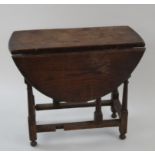 An oak drop leaf oval occasional table on turned legs linked by rectangular stretchers, 51cm high,