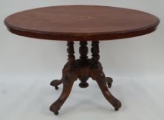 A Victorian walnut oval table with marquetry inset top on five turned supports with four carved