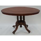 A Victorian walnut oval table with marquetry inset top on five turned supports with four carved