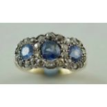 A sapphire and diamond three stone cluster ring, indistinct mark to the shank,