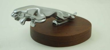 A Jaguar car ascot mounted on an oval mahogany plinth, mascot,